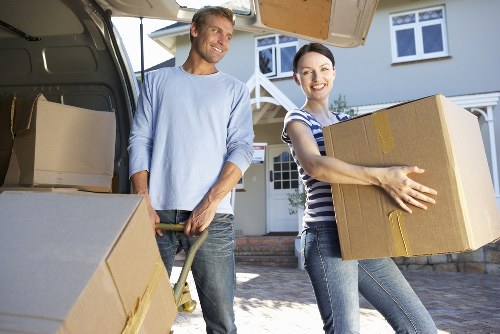 Professional movers carrying items down stairs in a local property