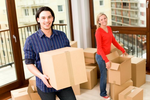 Local movers handling boxes and furniture near a North London flat